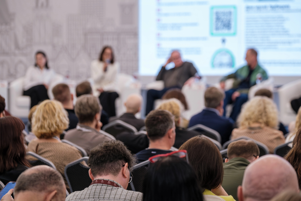 Firmenevent mit Redner auf beleuchteter Bühne