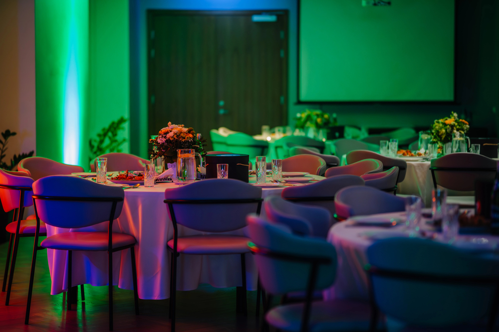 Firmenevent mit dezent beleuchtetem Saal und Bühne